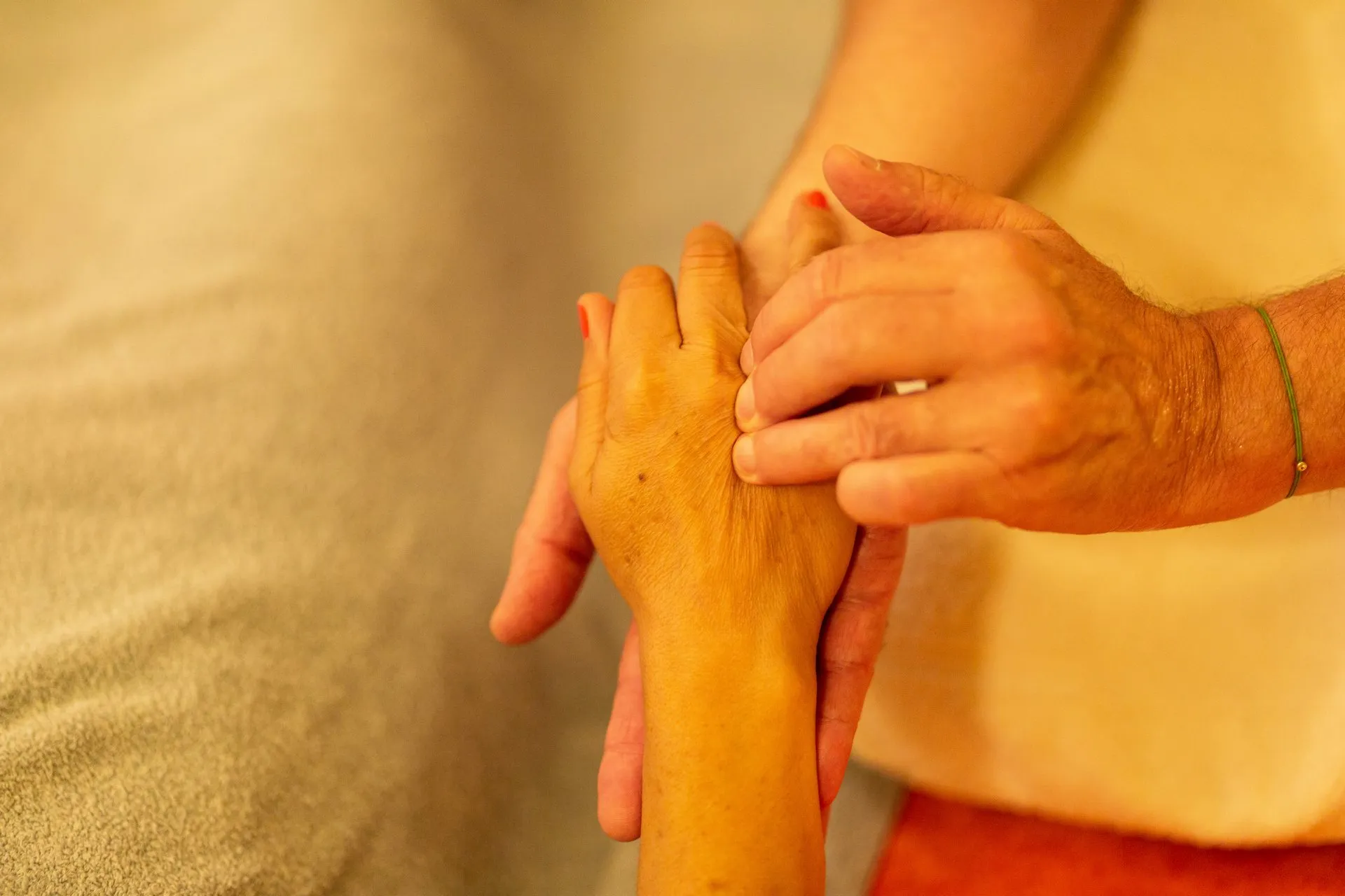 Mains du praticien massant l’avant-bras et la main d’une personne